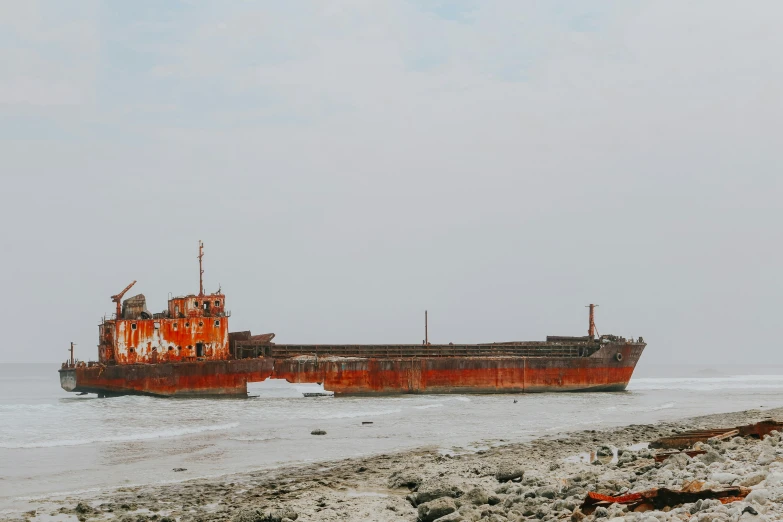 an old rusty ship on the beach with a sky background