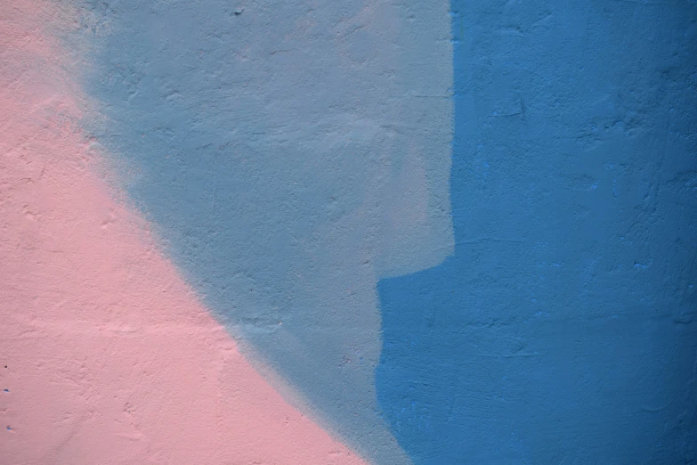 a shadow of a person on a blue and pink wall
