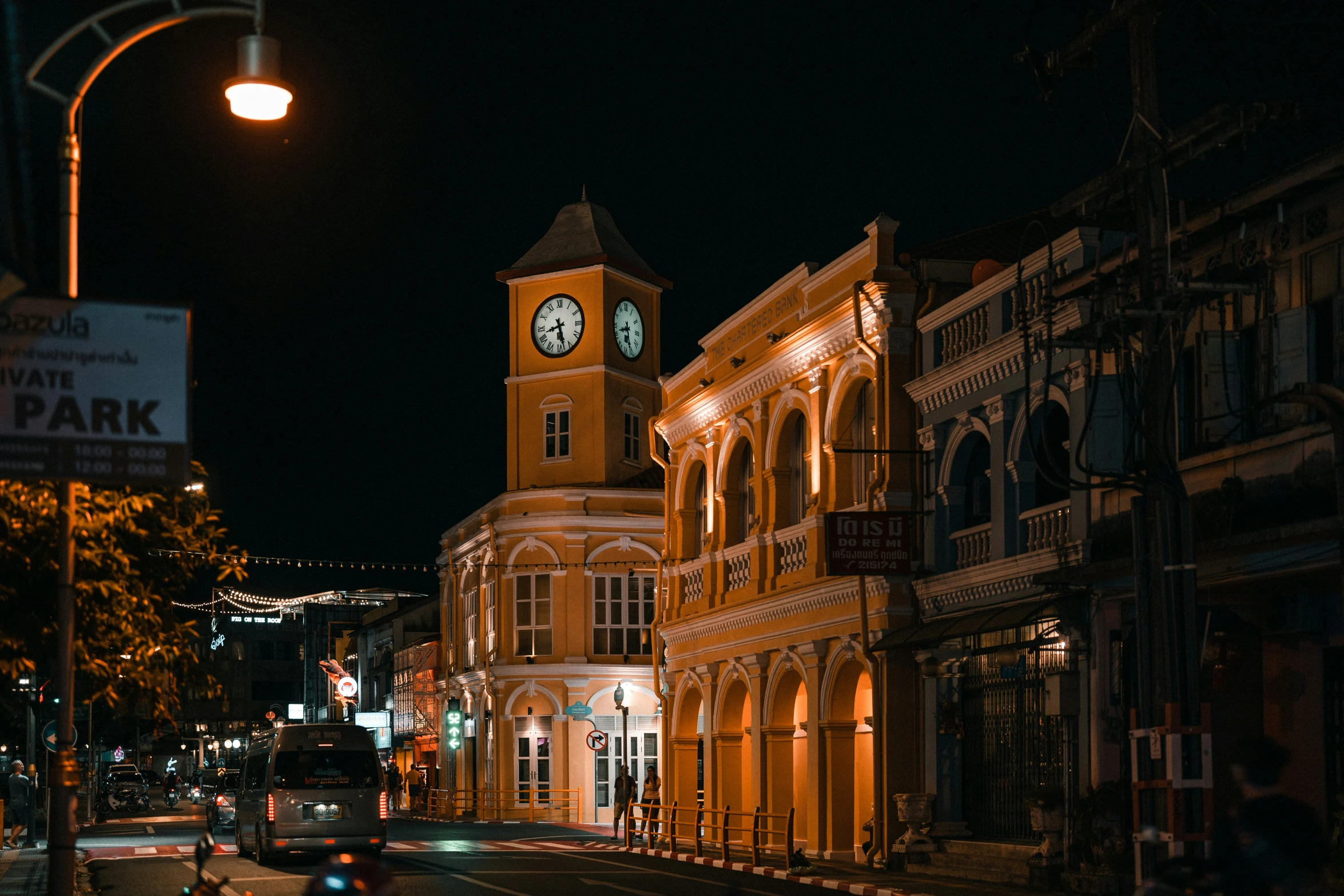 an illuminated clock tower in the middle of a city