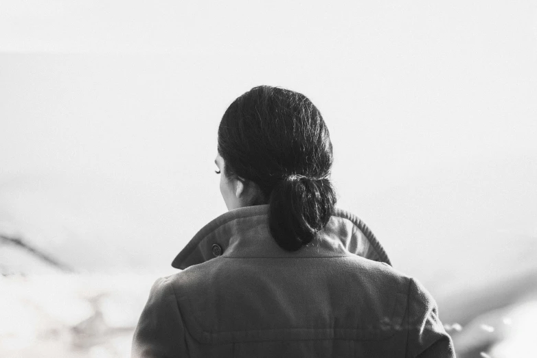 a woman stands in front of the ocean