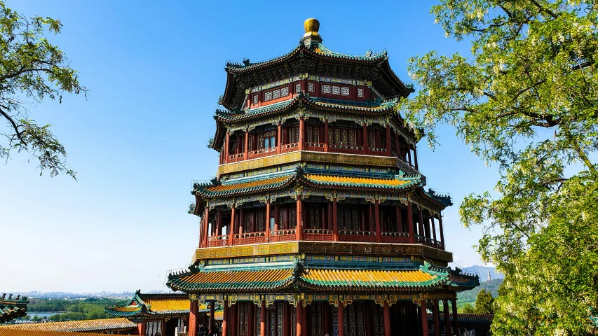 a tall red building with many windows next to a tree