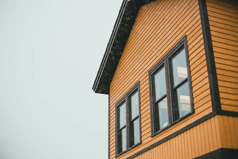 an up close picture of an old building with snow falling on the roof