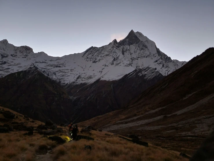 a couple of hikers are in the distance looking at mountains