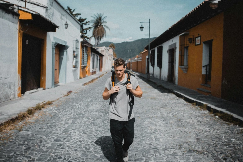 a man is walking down an alleyway and taking pictures with his cell phone