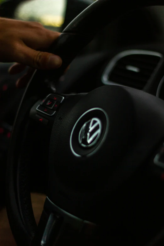 a hand on the steering wheel of a car