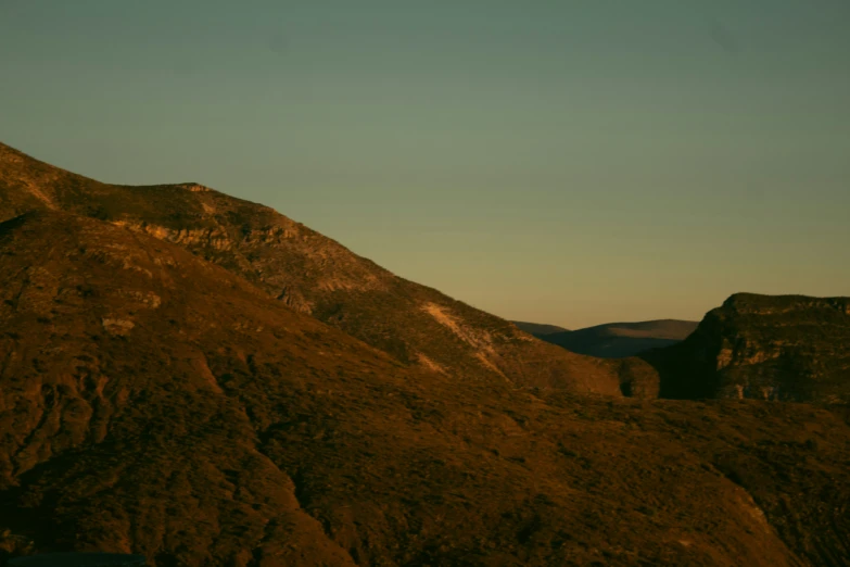 the mountain tops rise behind a clear blue sky