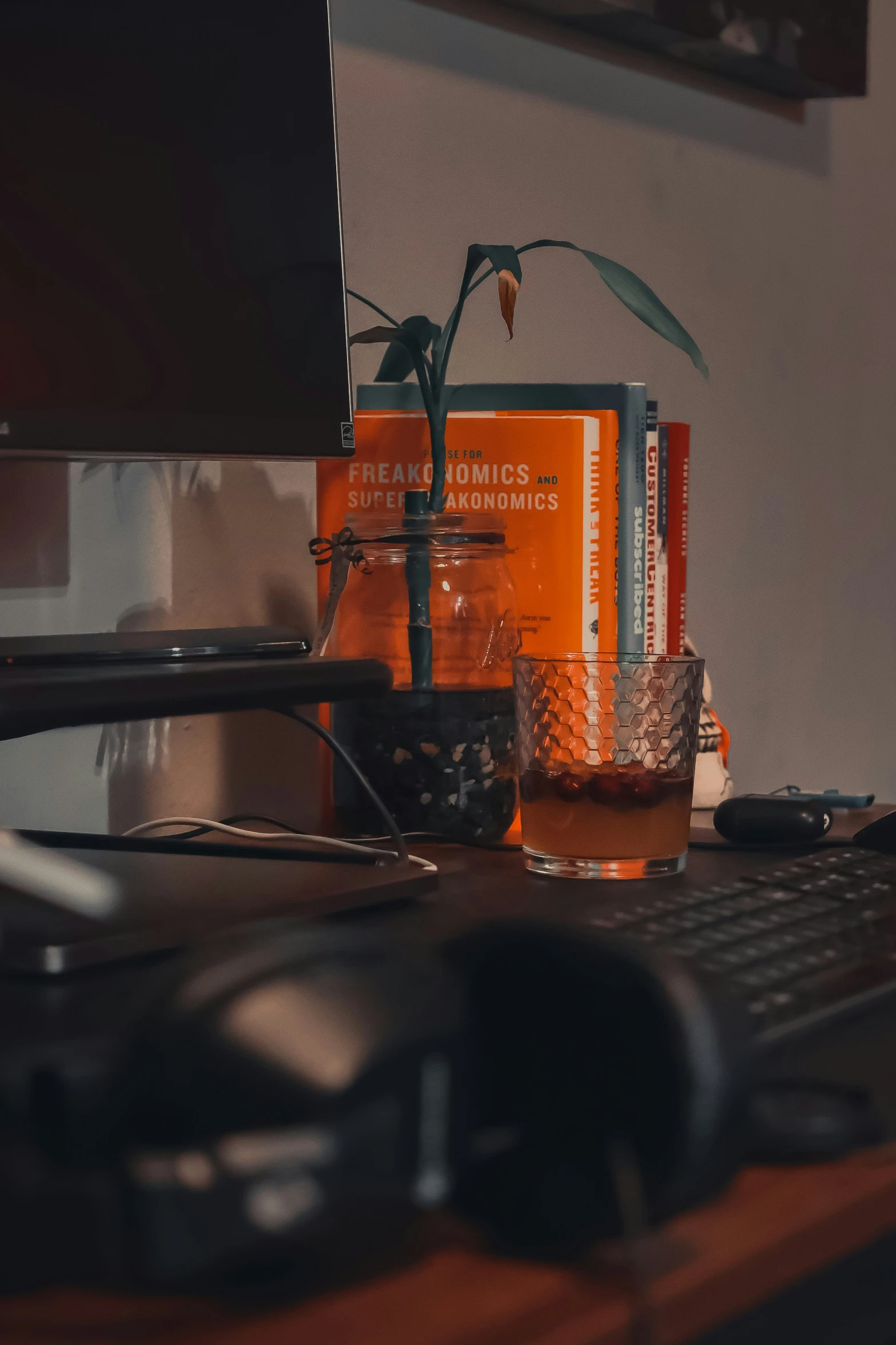 two orange cans sit next to a computer on a desk