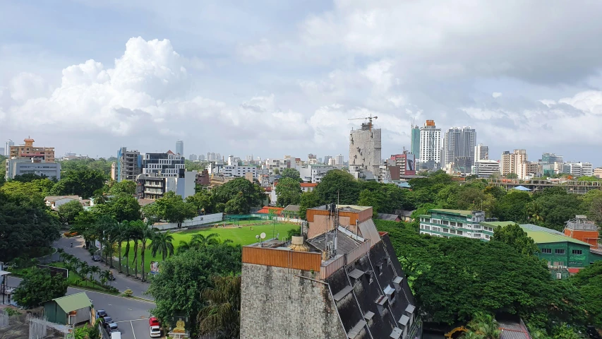 the city skyline is pictured with green and blue trees