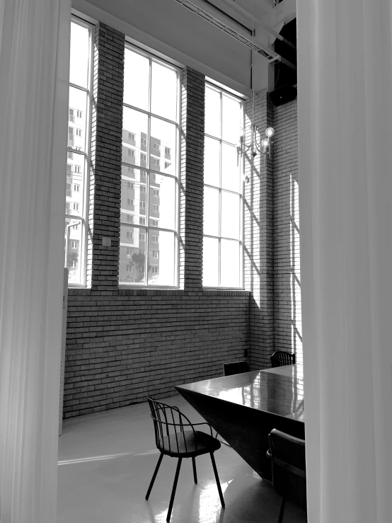 a dining room with two big windows and a wooden table