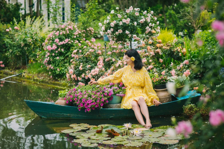 a woman in a yellow dress is on a canoe with water lillies