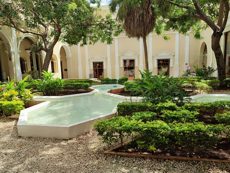 a large courtyard with fountains near a building