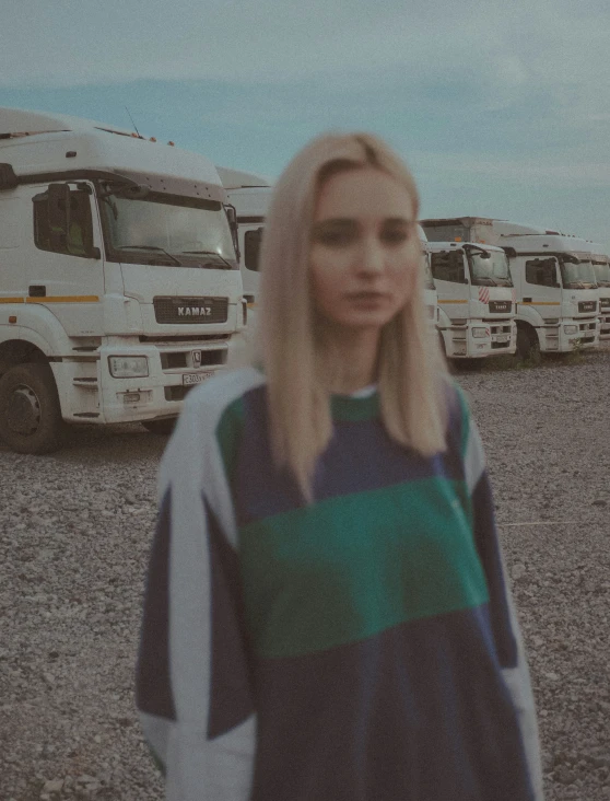 a woman standing in front of a row of parked trucks