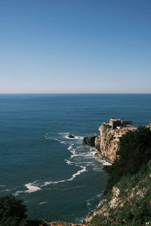 a cliff is near the beach on a bright day