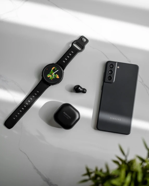 a phone with a watch and earphones on it