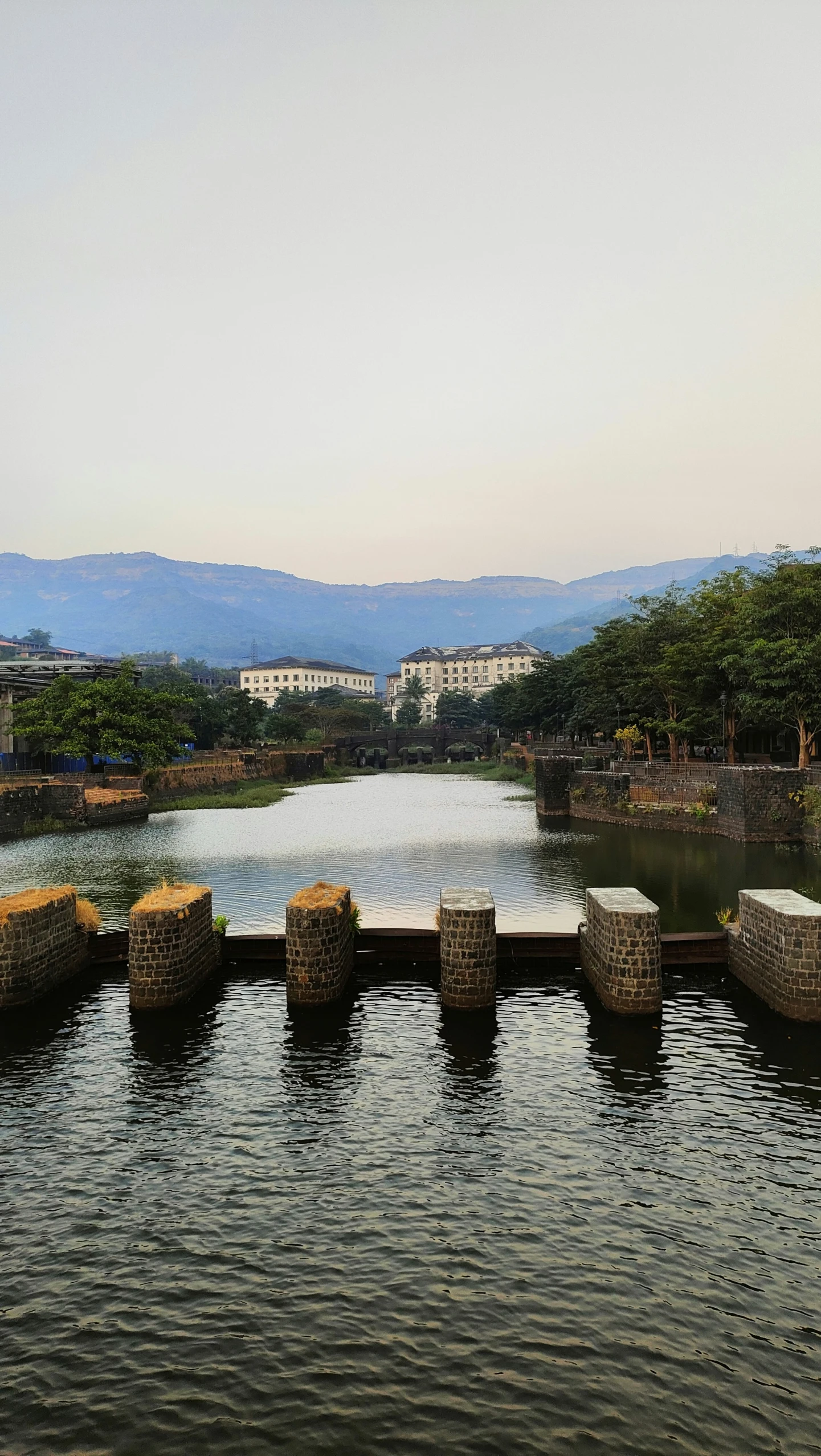 several cement benches sit beside the water in a park