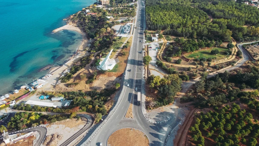 a very large road surrounded by trees near the water