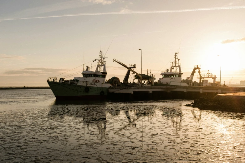 three fishing boats are moored at the dock