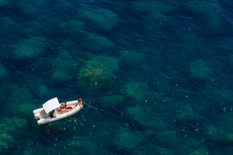 a small boat floating on top of a blue ocean