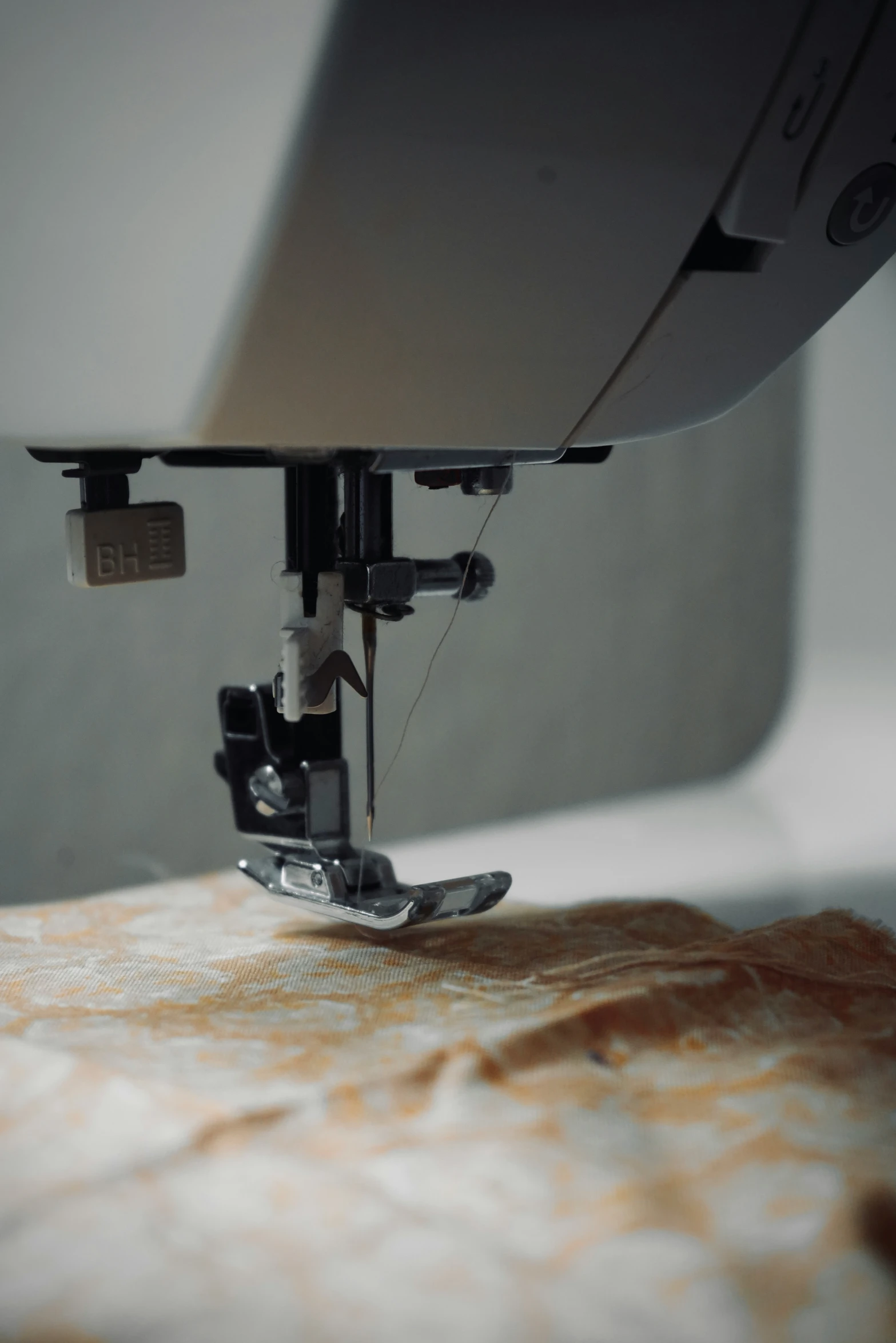 the sewing machine threads a needle through the center of the sewing machine