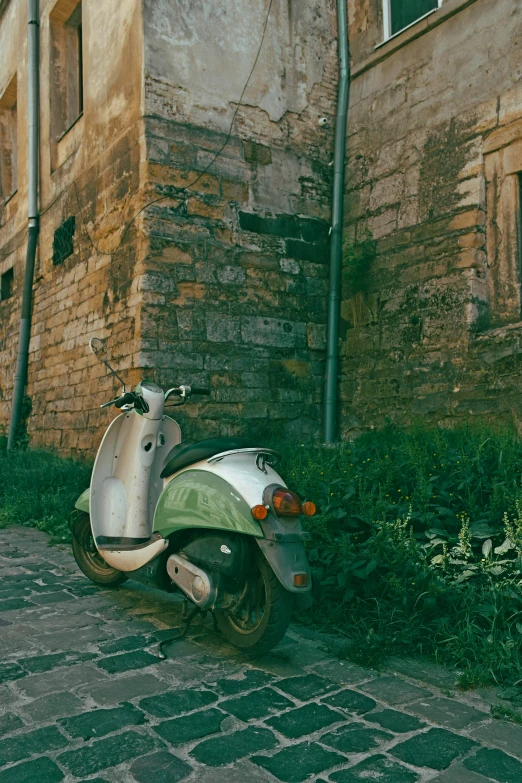 a white and green moped is on the street