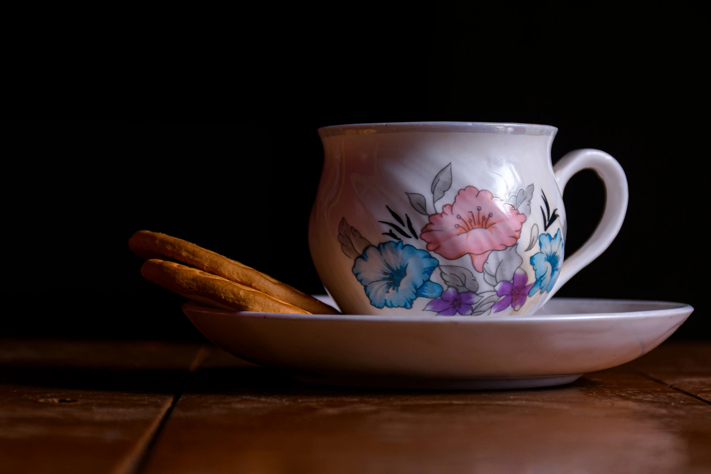 there is a white coffee cup and some cookies in a plate