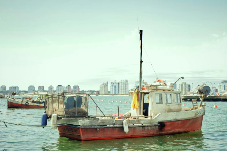 a red and white boat parked in the water next to another boat