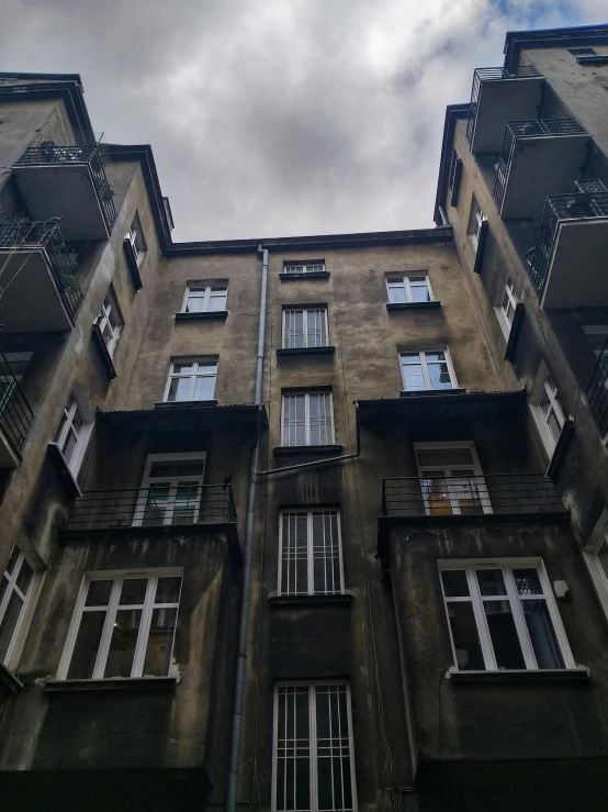 a tall building with multiple stories under a cloudy sky