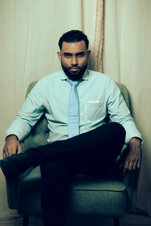 a man sitting on top of a chair with his feet crossed