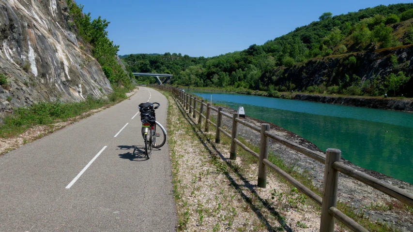 a bicycle is leaning on the fence while going down a hill