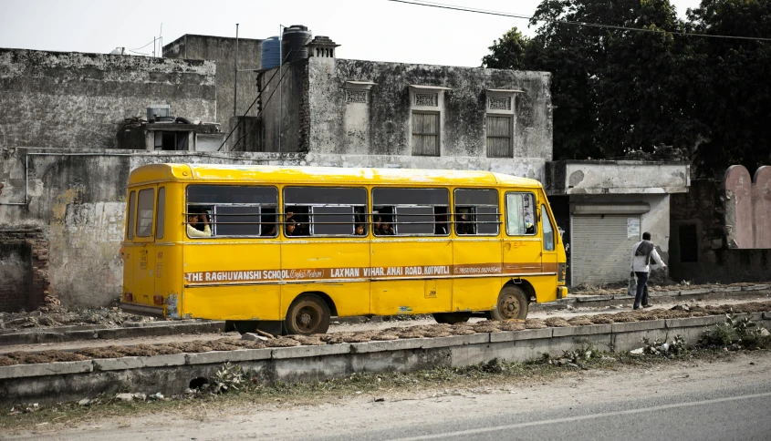 an old yellow bus parked next to a building