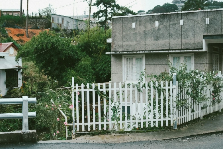 an old fashioned home with a white picket fence near trees