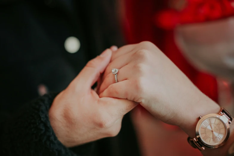 a person putting their wedding ring on someone's wrist