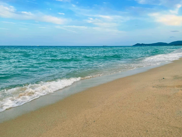 an ocean beach next to a large island