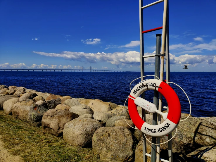 the red and white lifeguard pole stands next to a body of water