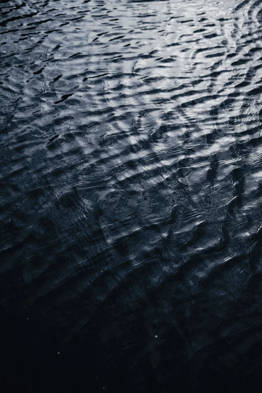 water has ripples on the surface as it travels in the wind