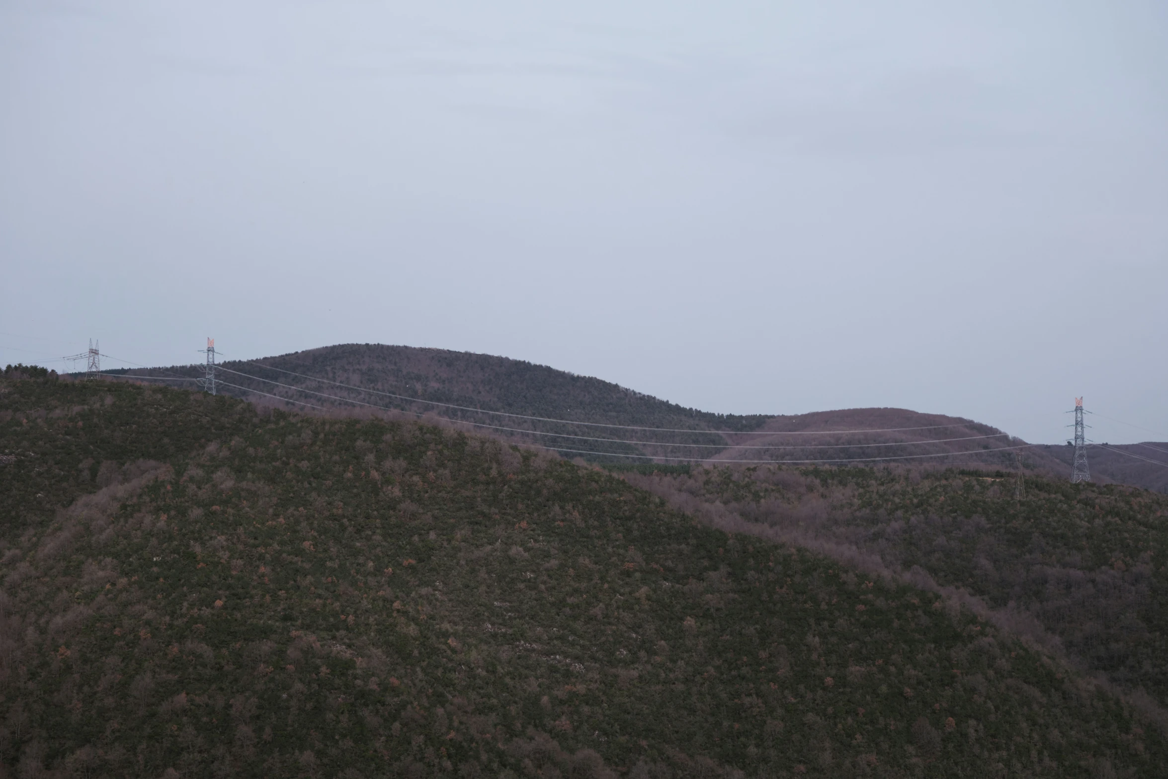 a hill with a wooden fence in the foreground