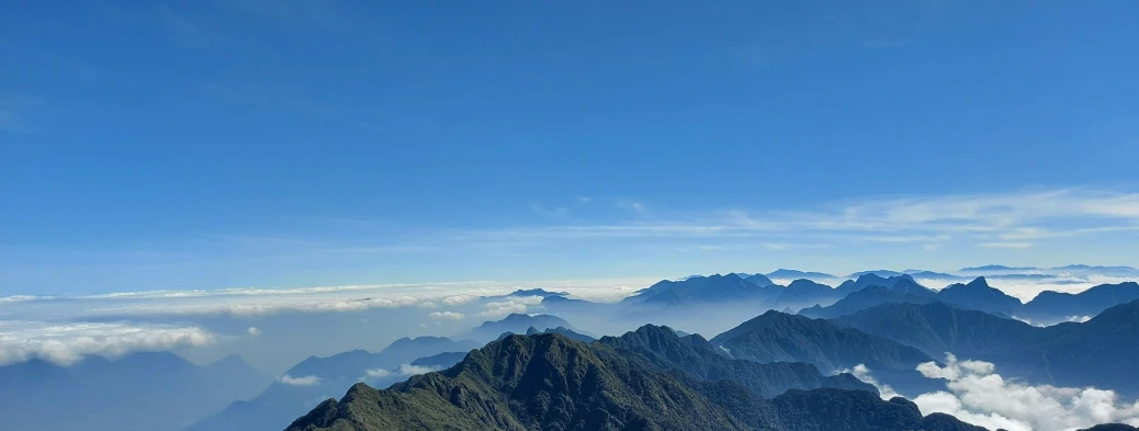 view of mountains covered with clouds and blue sky