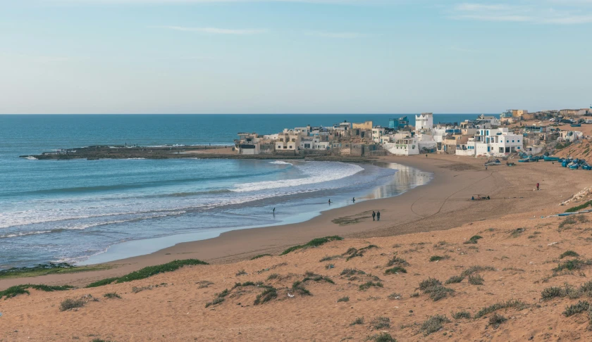 there is a very beautiful sandy beach with buildings on it