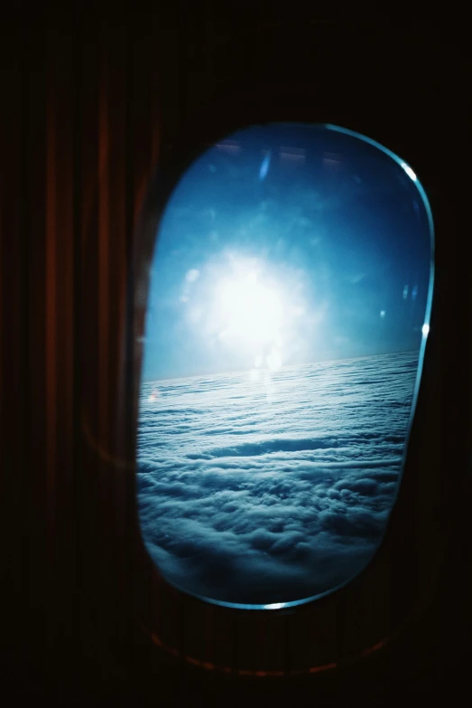 a view out of the window of a plane of a foggy ocean below