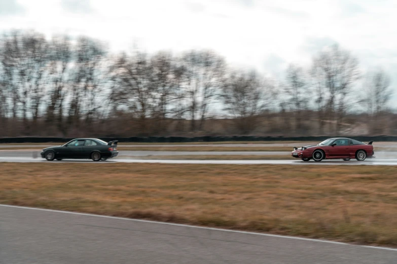 two small vehicles drive on a wet highway