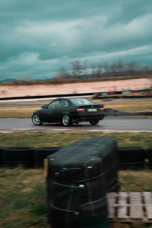 the black car is driving in the rain