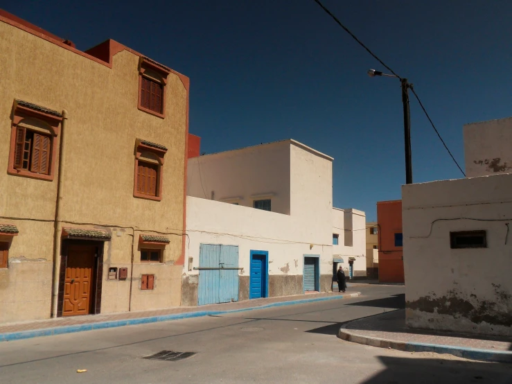 a small empty street with two houses in the back