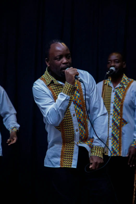 a man in a tie singing into a microphone