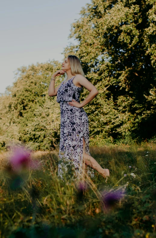 a woman standing in the middle of a grassy field