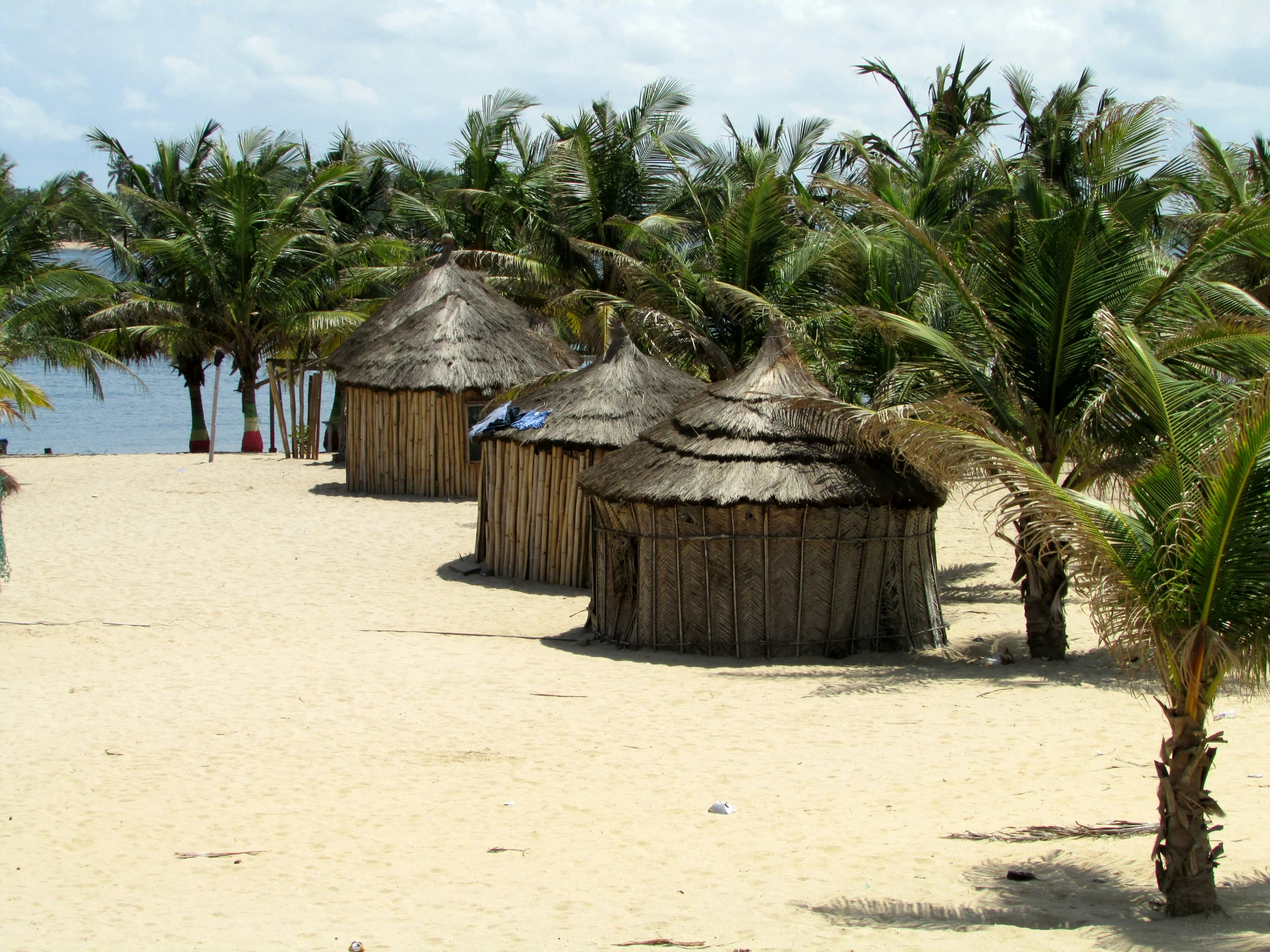 several small huts are set next to the ocean