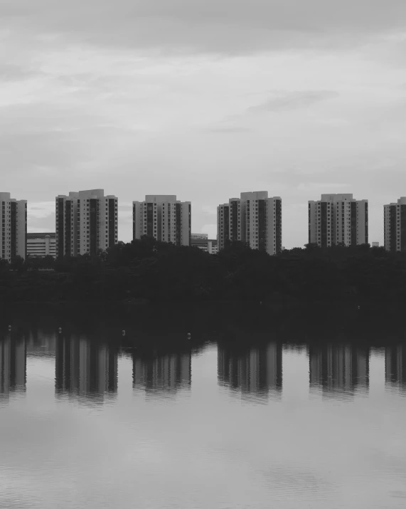 a city is reflected in the still lake water