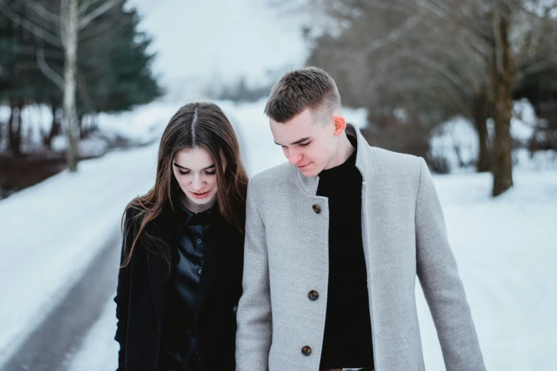 a couple walking through snow in the winter