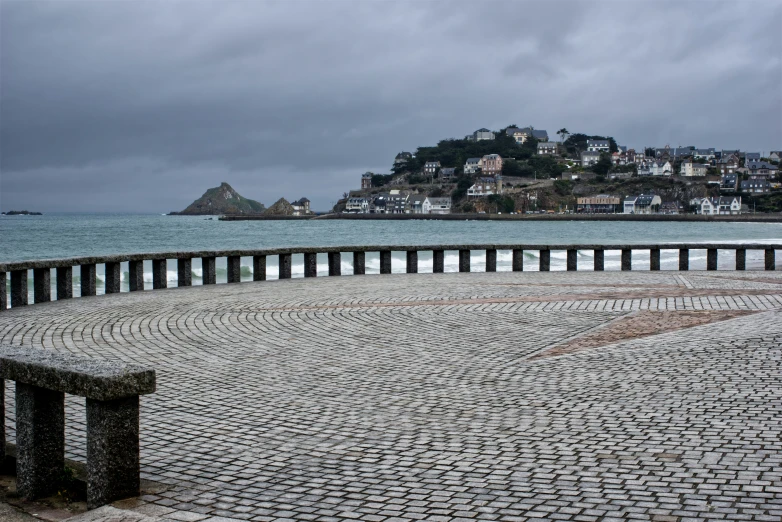 a stone bench sitting in front of a body of water