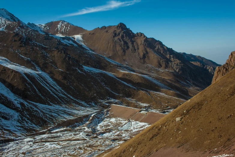 two mountains are shown with snow covered patches