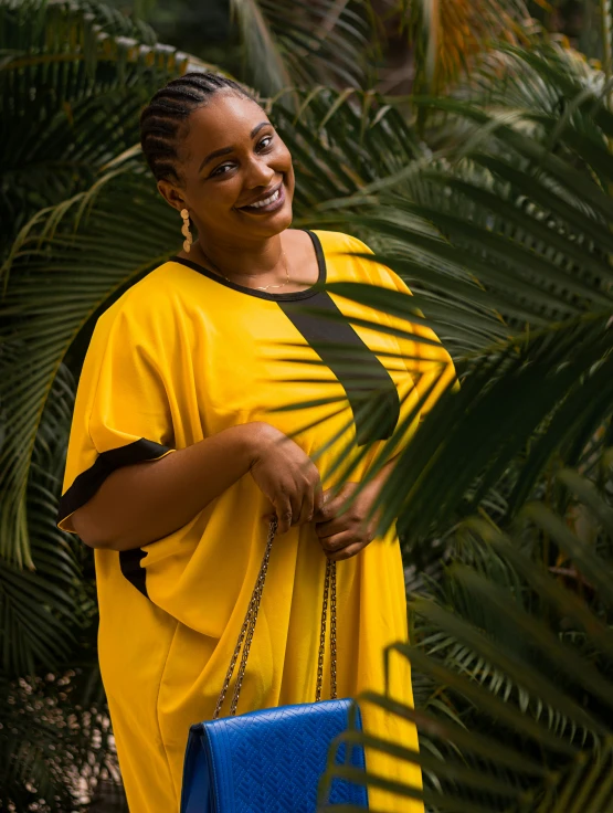 a woman in a yellow dress holding a blue purse